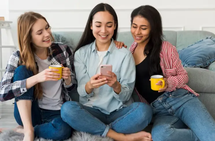 Tres personas usando un celular desde casa